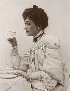 Nineteenth-century woman in white drinking from a china tea cup.